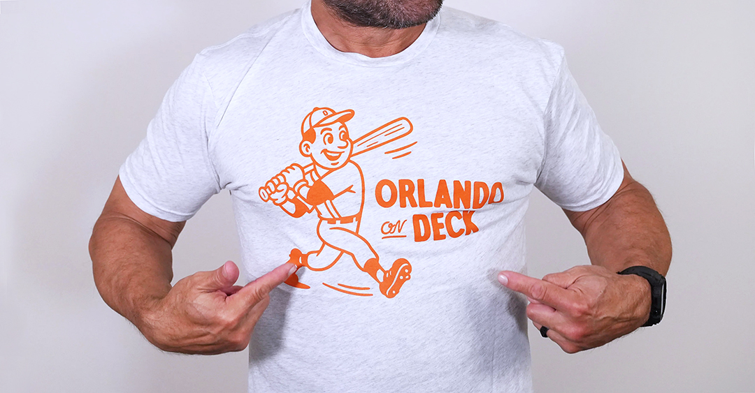 A man wearing an Orlando On Deck shirt and pointing to the logo.